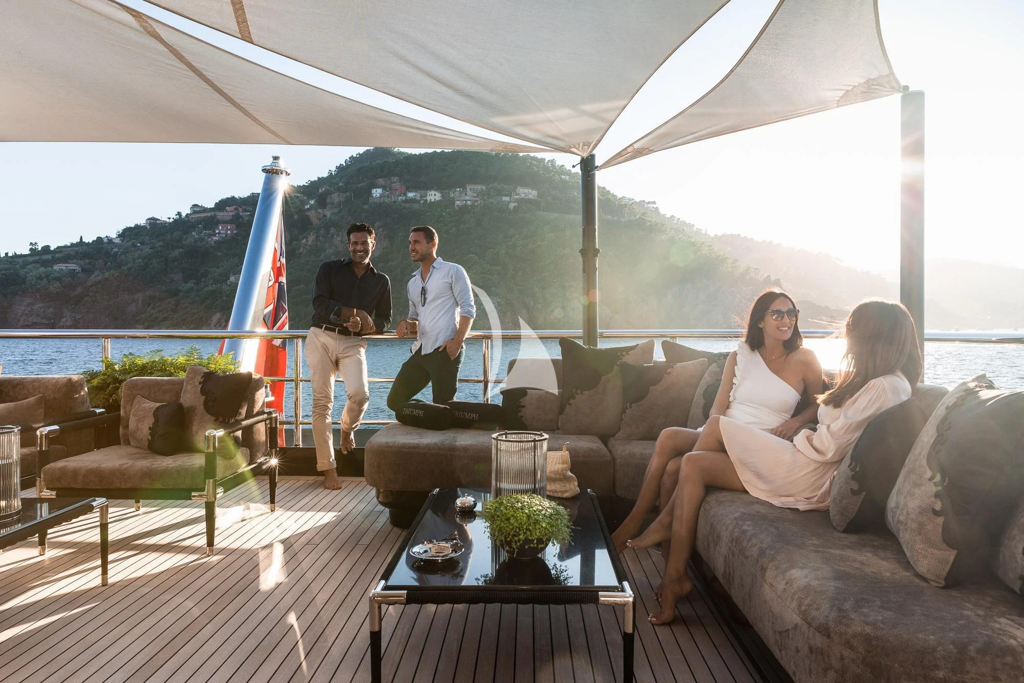 a group of people standing around a table outside aboard TRIUMPH Yacht for Sale