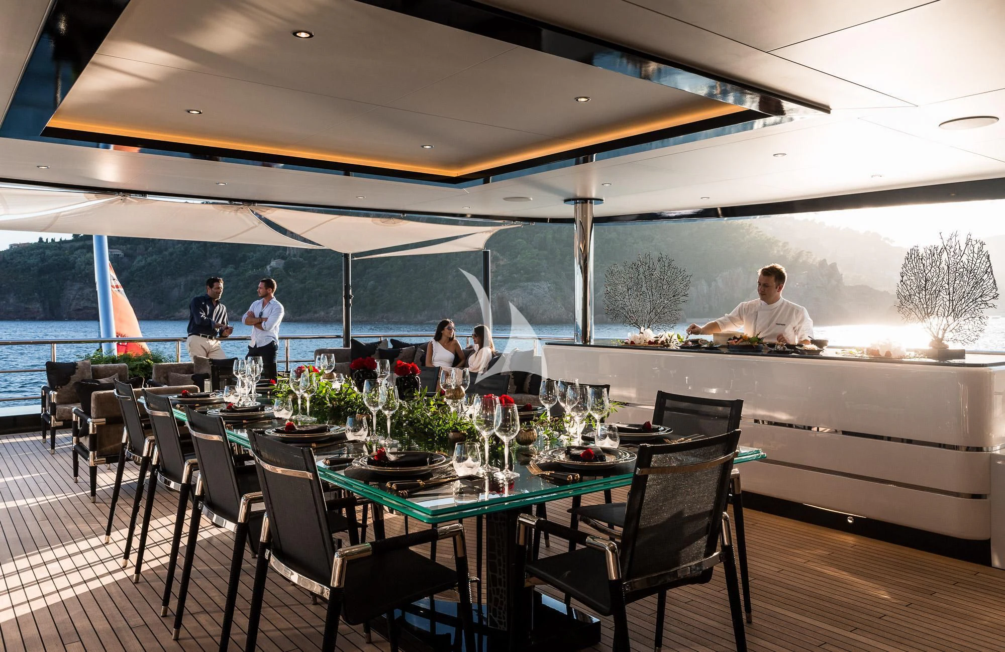 a group of people sitting at a table with a large glass window aboard TRIUMPH Yacht for Sale