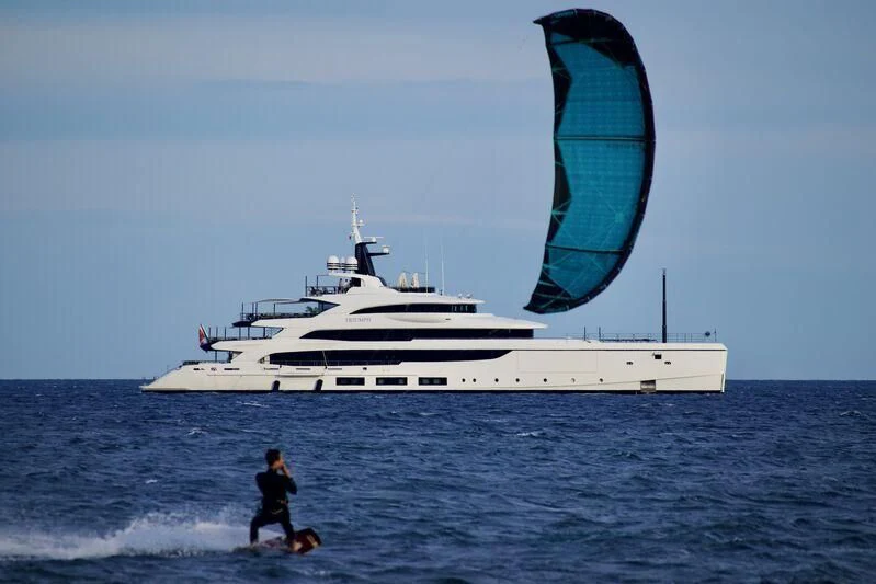 a person walking in the water next to a large boat aboard TRIUMPH Yacht for Sale