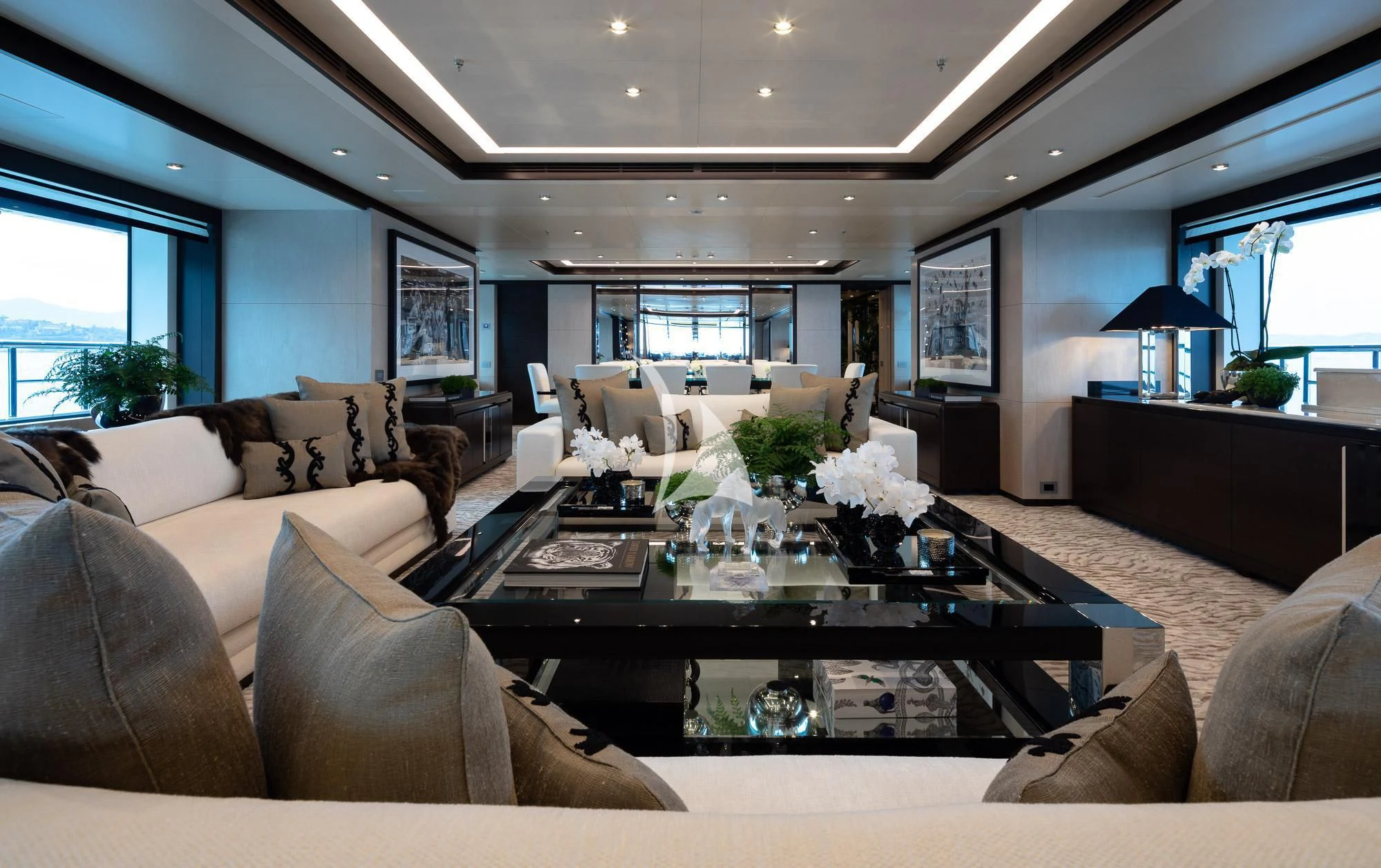 a living room with a large glass coffee table and a large window aboard TRIUMPH Yacht for Sale
