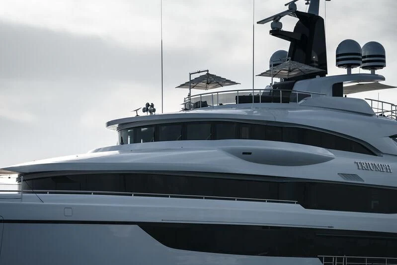 a white yacht with a wind turbine on top aboard TRIUMPH Yacht for Sale