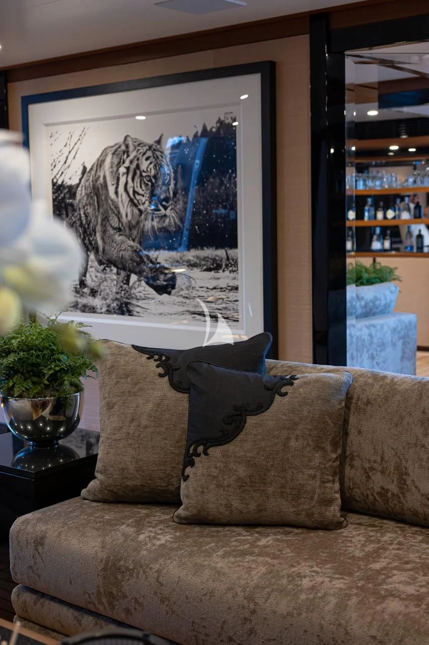 a couch with a painting on the wall aboard TRIUMPH Yacht for Sale