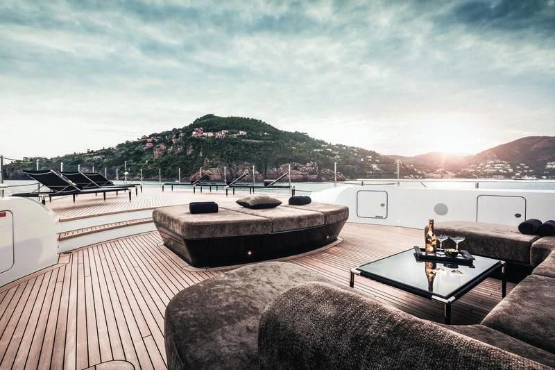 a deck with a table and a guitar on it aboard TRIUMPH Yacht for Sale