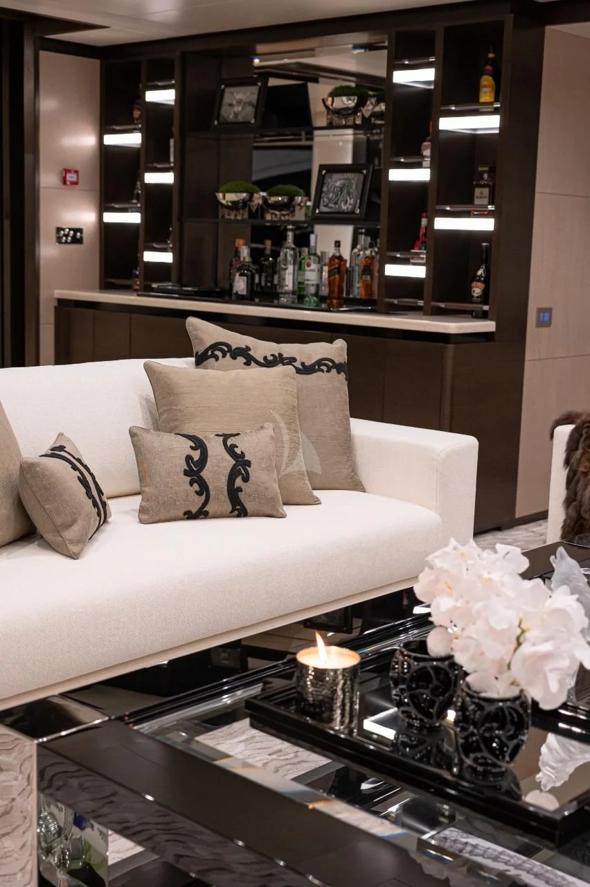 a living room with a white couch and a shelf with objects on it aboard TRIUMPH Yacht for Sale