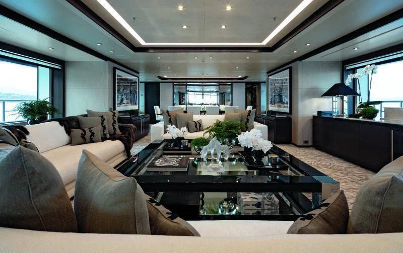 a living room with a large glass coffee table and a large window aboard TRIUMPH Yacht for Sale
