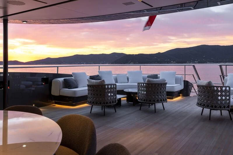 a deck with chairs and a body of water in the background aboard BEL 1 Yacht for Sale