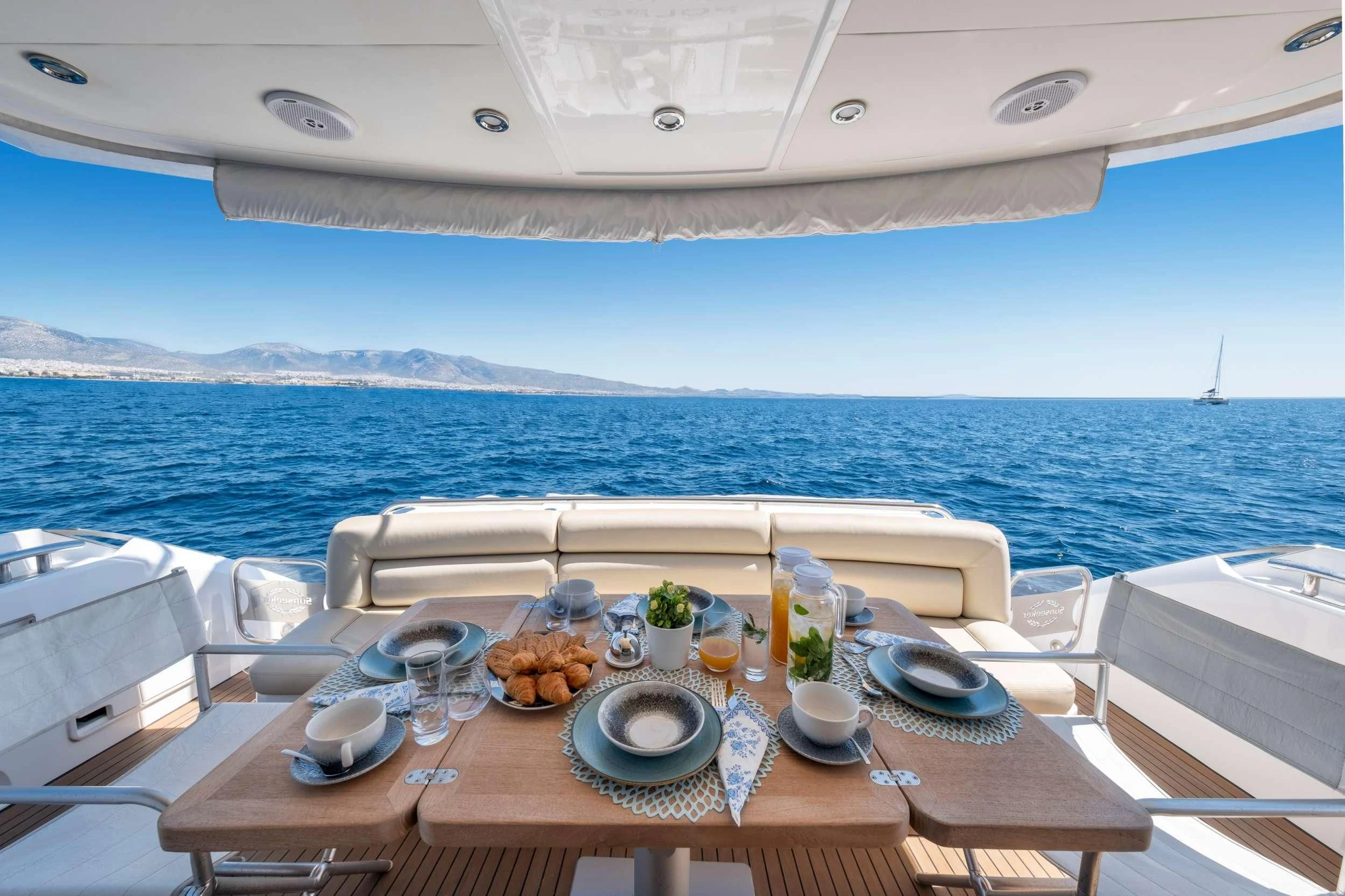 a table with plates and food on it by the ocean aboard POLPO Yacht for Charter