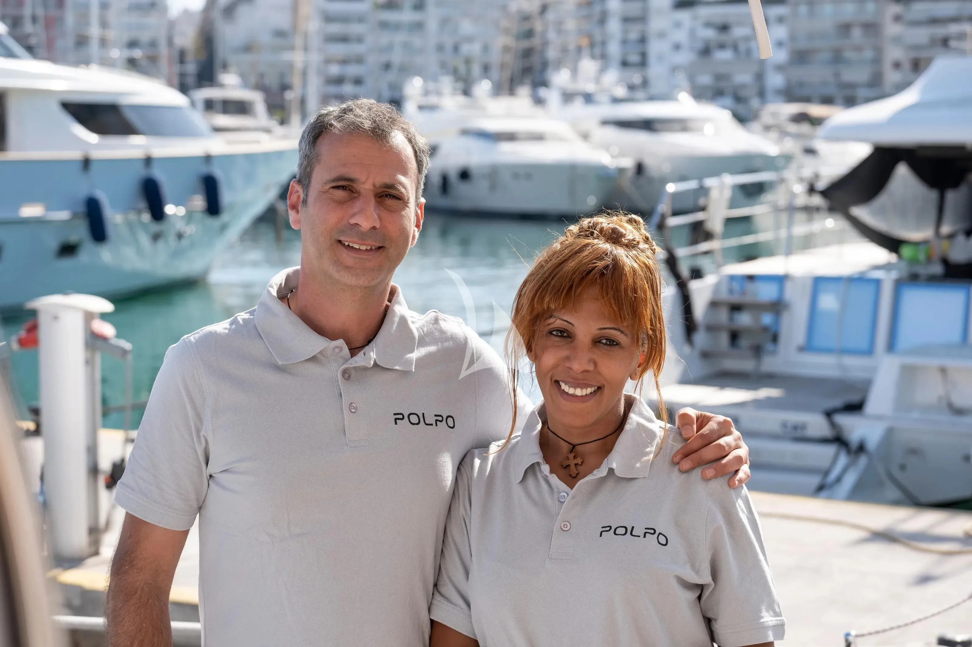 a man and woman standing next to each other smiling aboard POLPO Yacht for Charter