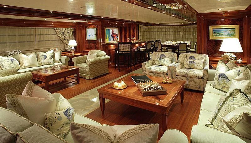 a living room with a piano and a table aboard EMELINA Yacht for Sale