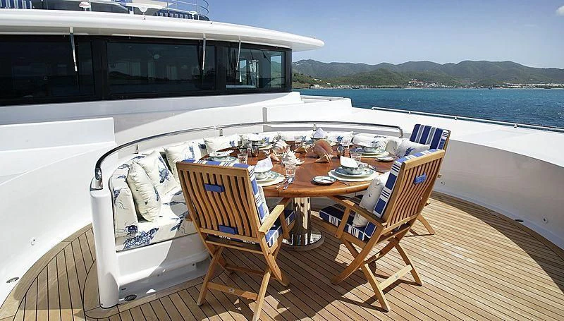 a deck with a table and chairs on it aboard EMELINA Yacht for Sale