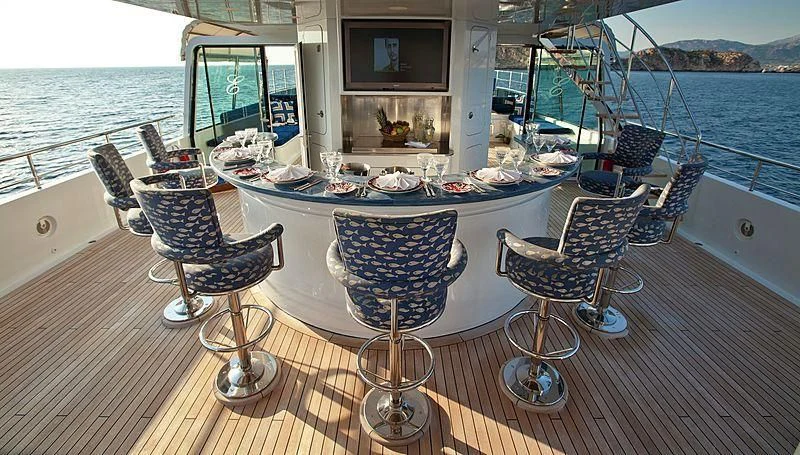 a table with chairs on it next to a large body of water aboard EMELINA Yacht for Sale