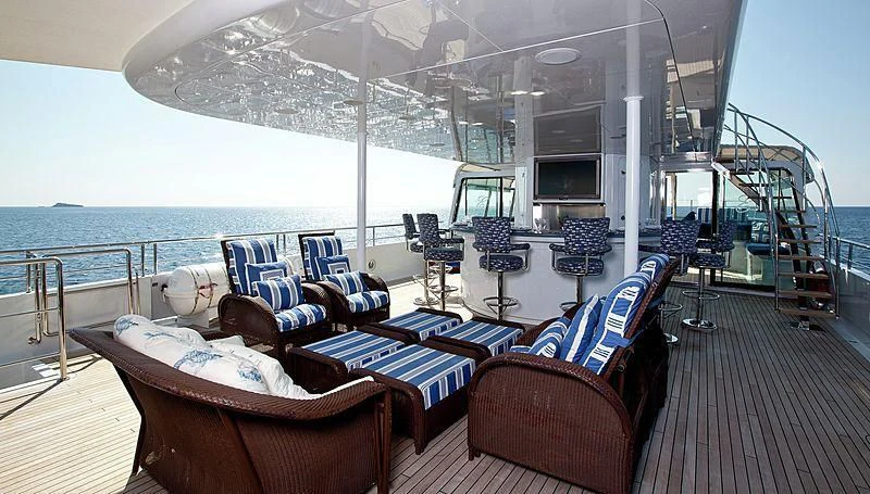 a deck with chairs and a table on it aboard EMELINA Yacht for Sale