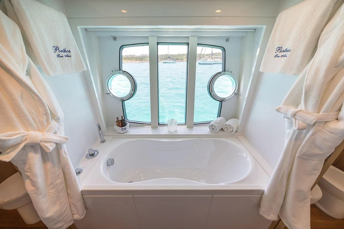 a bathroom with a bathtub and towels aboard PORTHOS SANS ABRI Yacht for Sale