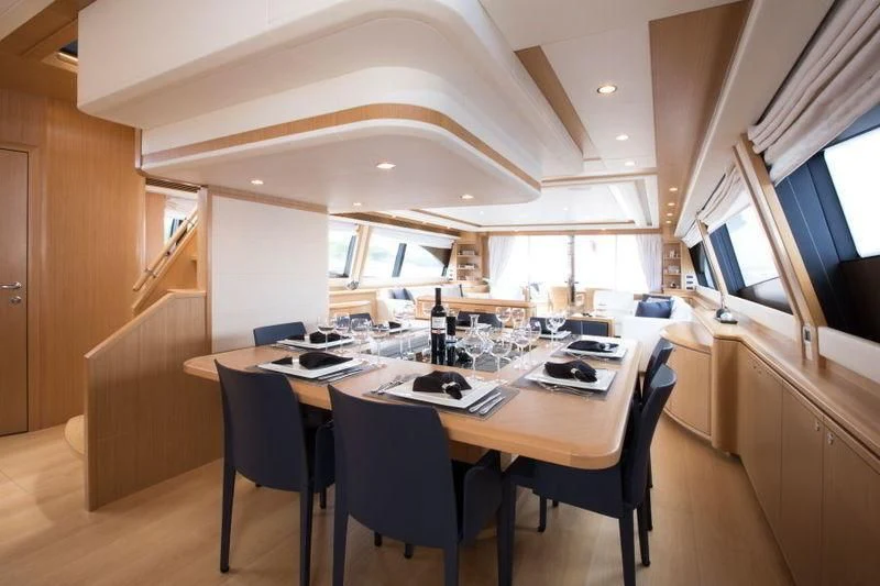 a table with chairs and a laptop on it aboard PORTHOS SANS ABRI Yacht for Sale