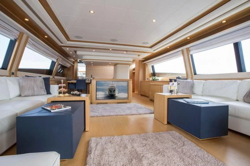 a living room with a couch and a table aboard PORTHOS SANS ABRI Yacht for Sale