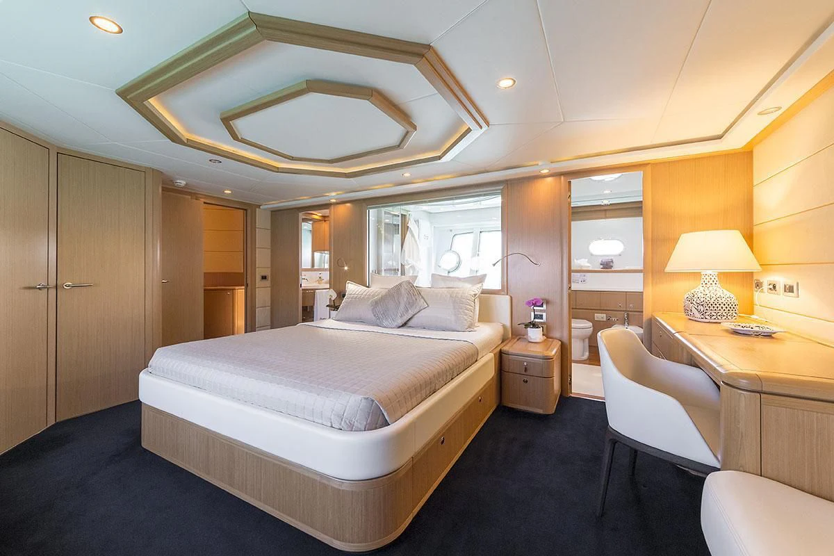 a large bedroom with a bed and desk aboard PORTHOS SANS ABRI Yacht for Sale