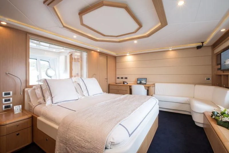 a bedroom with a bed and a couch aboard PORTHOS SANS ABRI Yacht for Sale