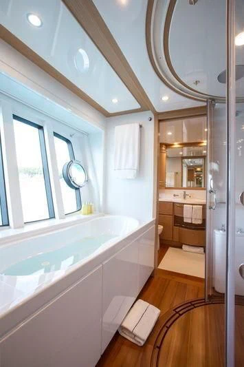 a bathroom with a tub and sink aboard PORTHOS SANS ABRI Yacht for Sale