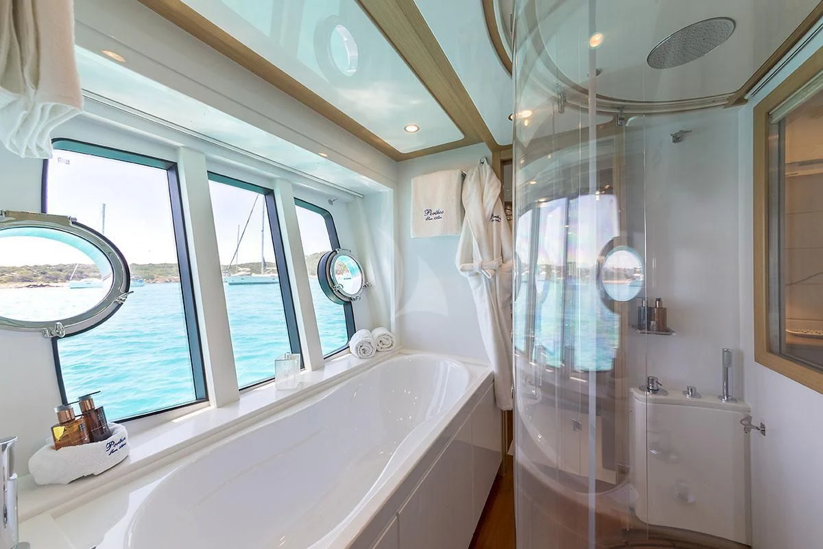 a bathroom with a shower and bathtub aboard PORTHOS SANS ABRI Yacht for Sale