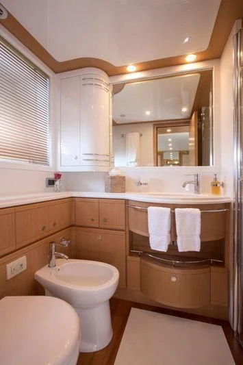 a bathroom with wooden cabinets aboard PORTHOS SANS ABRI Yacht for Sale