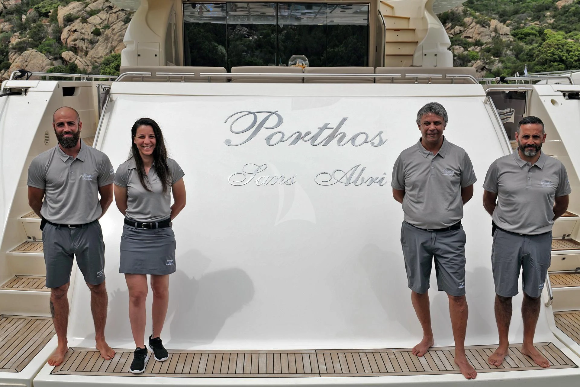 a group of people standing next to a white board with writing on it aboard PORTHOS SANS ABRI Yacht for Sale