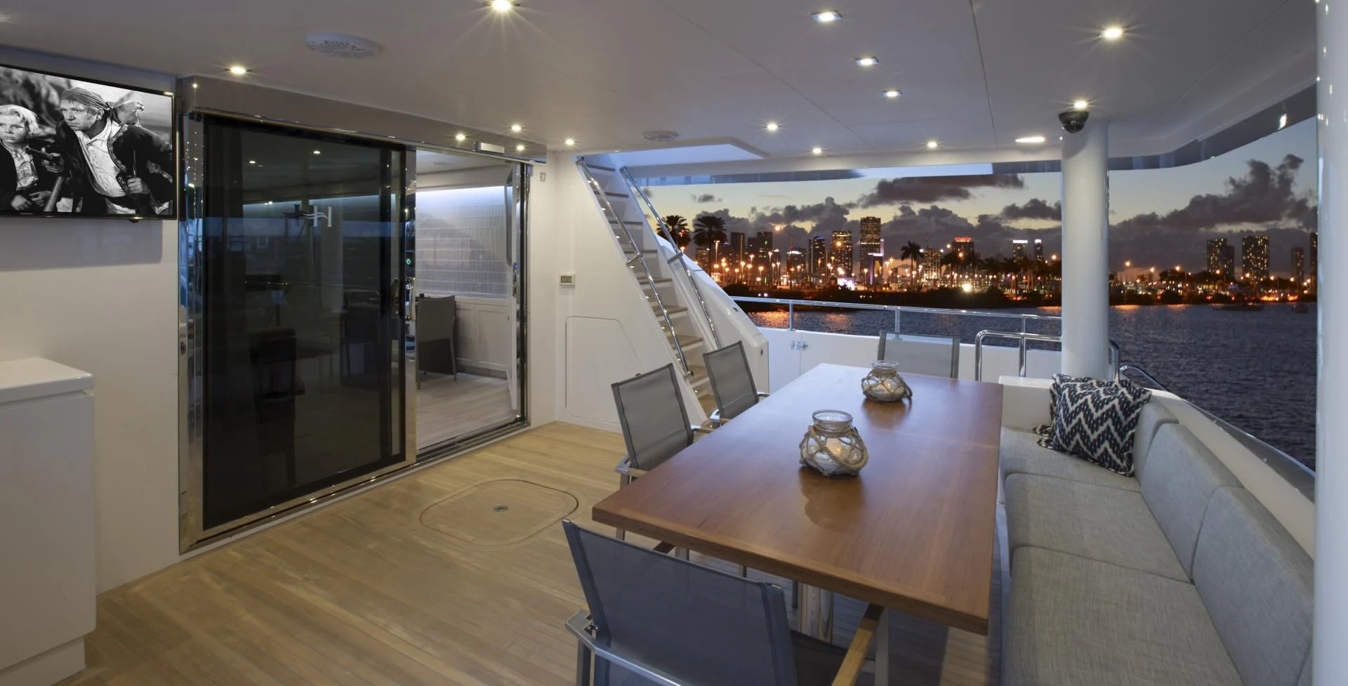 a room with a table and a couch and a window with a view of a city aboard SEASEID Yacht for Sale