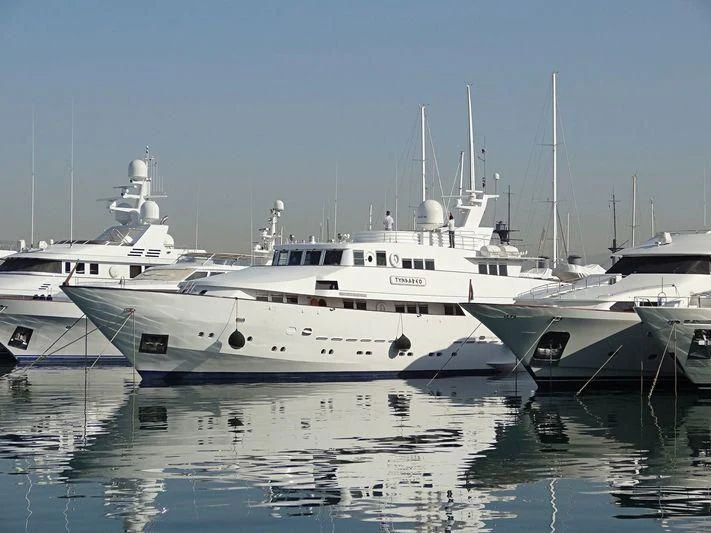 a group of white yachts with USS Potomac (AG-25) in the background aboard TYNDAREO Yacht for Sale