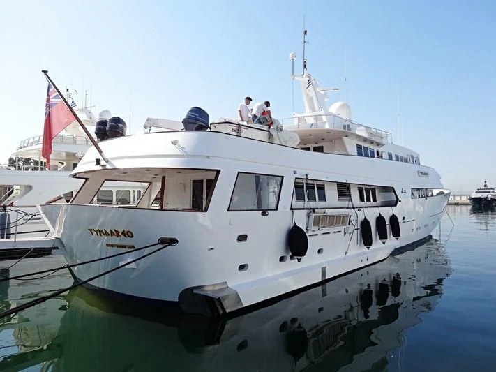a boat with a flag on the front aboard TYNDAREO Yacht for Sale