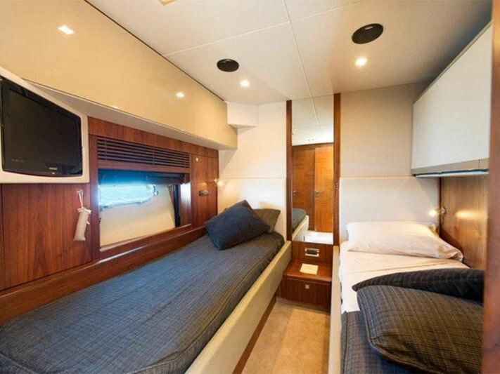 a bedroom with a bed and a tv aboard NEMESIS Yacht for Sale