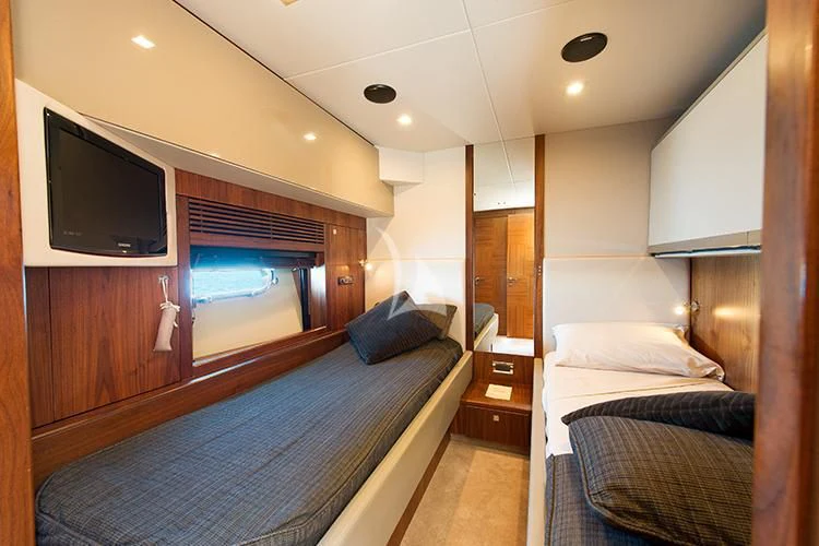 a bedroom with a bed and a tv aboard NEMESIS Yacht for Sale