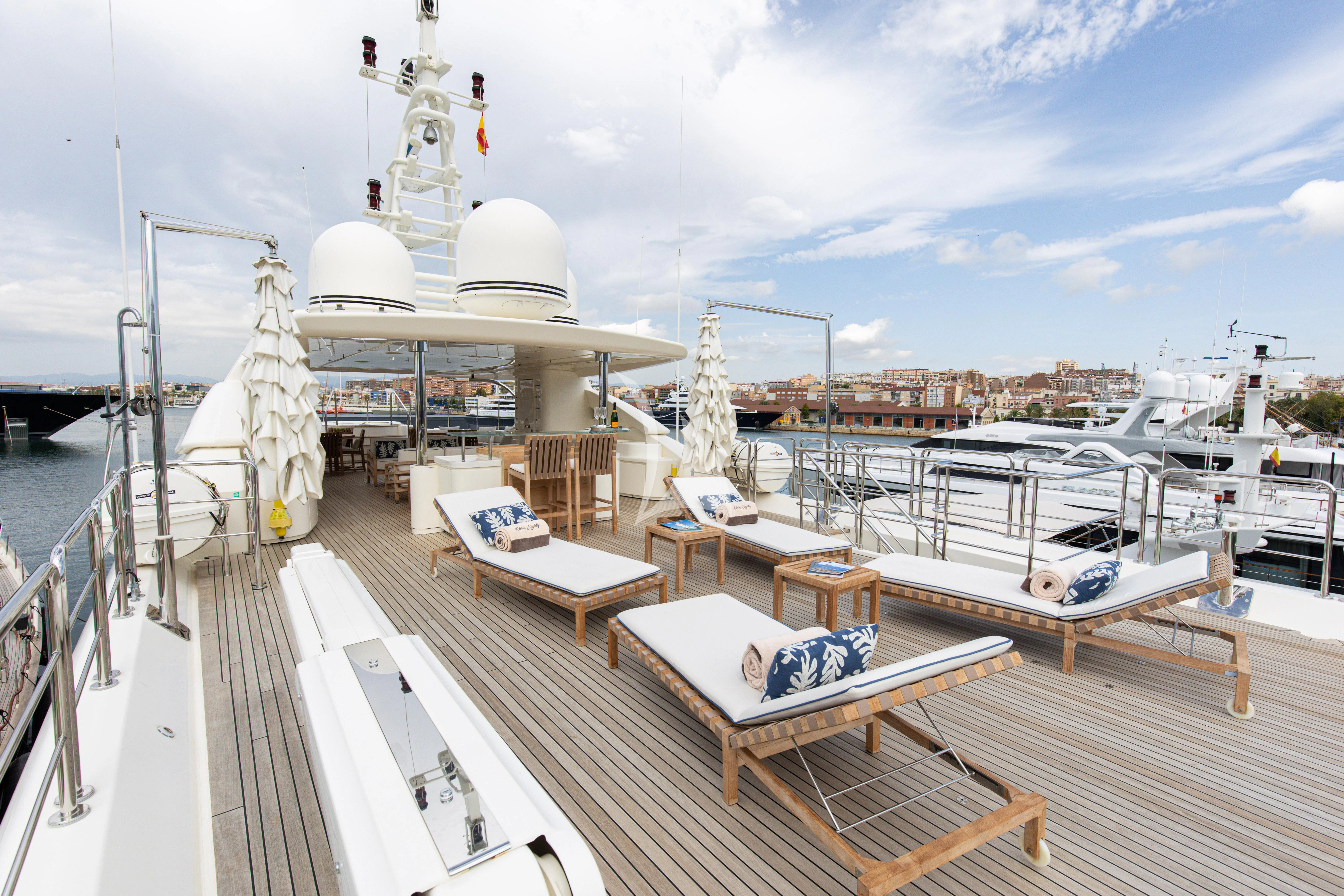 a deck with a deck and a large ship in the water aboard PALATIAL Yacht for Sale