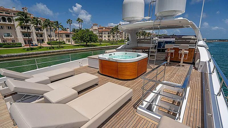 a deck with a deck and a pool with a building and trees aboard SHELLS X Yacht for Sale