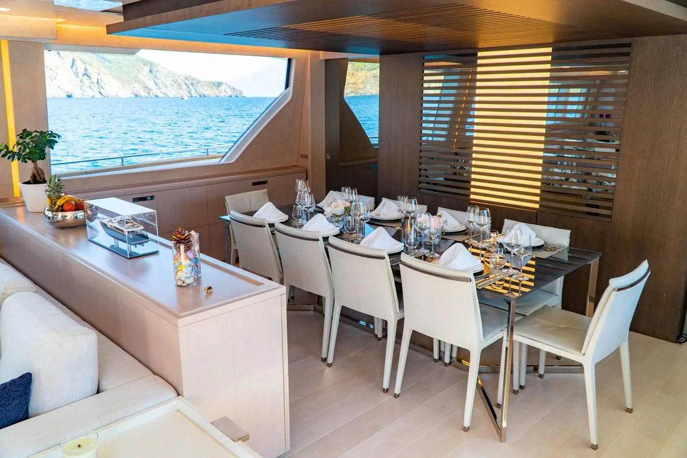 a dining table with chairs and a large window aboard SHELLS X Yacht for Sale
