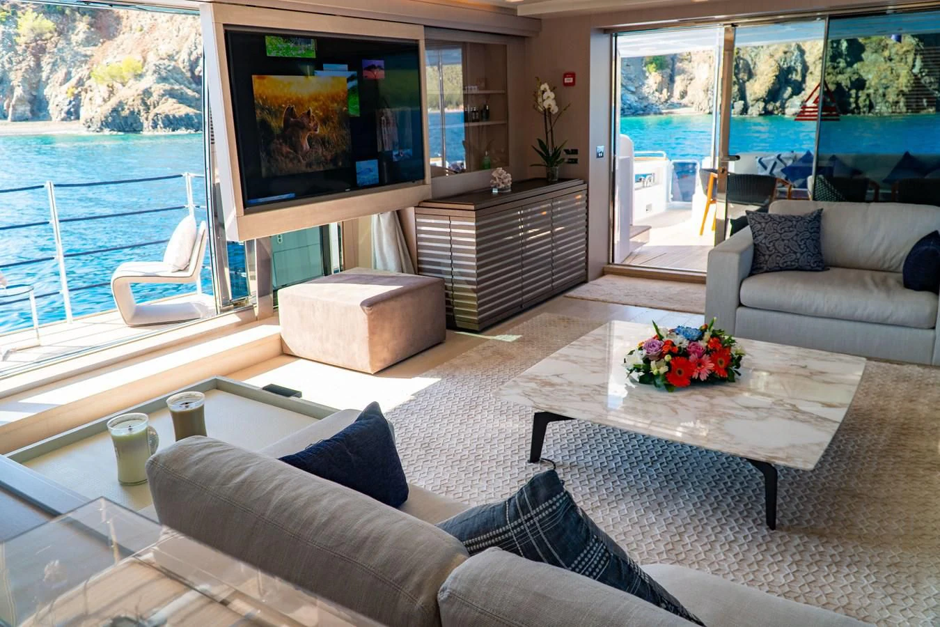 a living room with a large screen aboard SHELLS X Yacht for Sale
