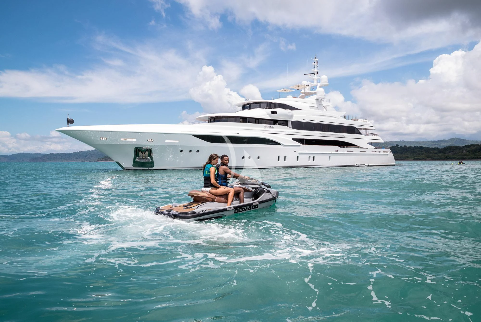 a couple people in a boat in the water with a large white boat in the background aboard FORMOSA Yacht for Sale