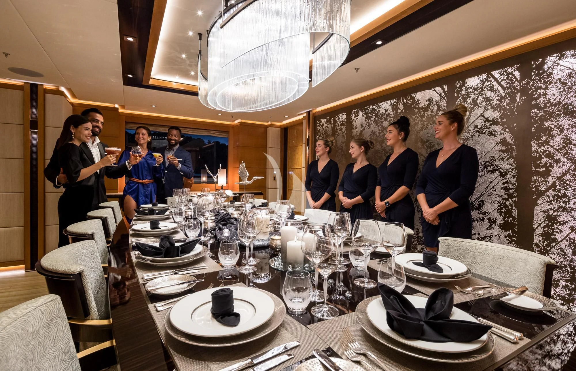 a group of people standing around a table with plates and glasses on it aboard FORMOSA Yacht for Sale