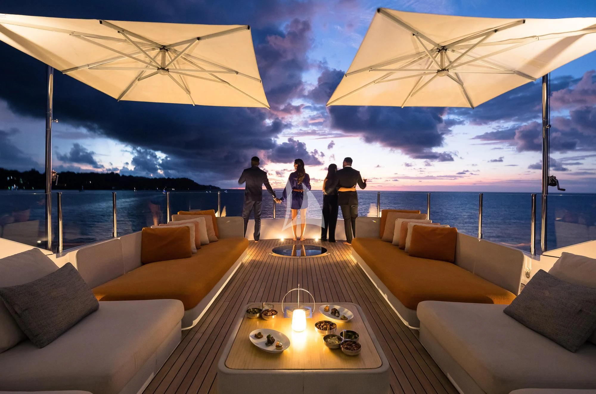 a group of people standing on a deck looking out over the water aboard FORMOSA Yacht for Sale
