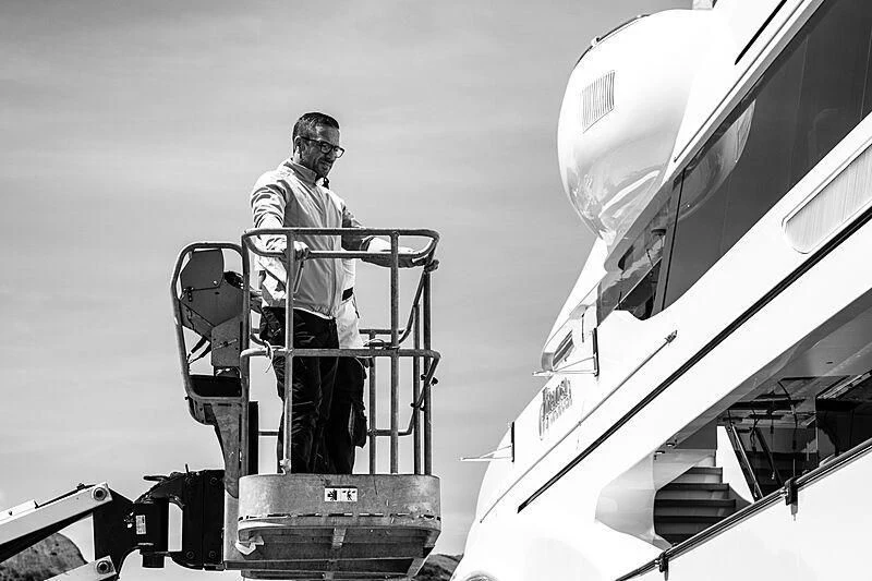 a man standing on a ladder next to a plane aboard FORMOSA Yacht for Sale