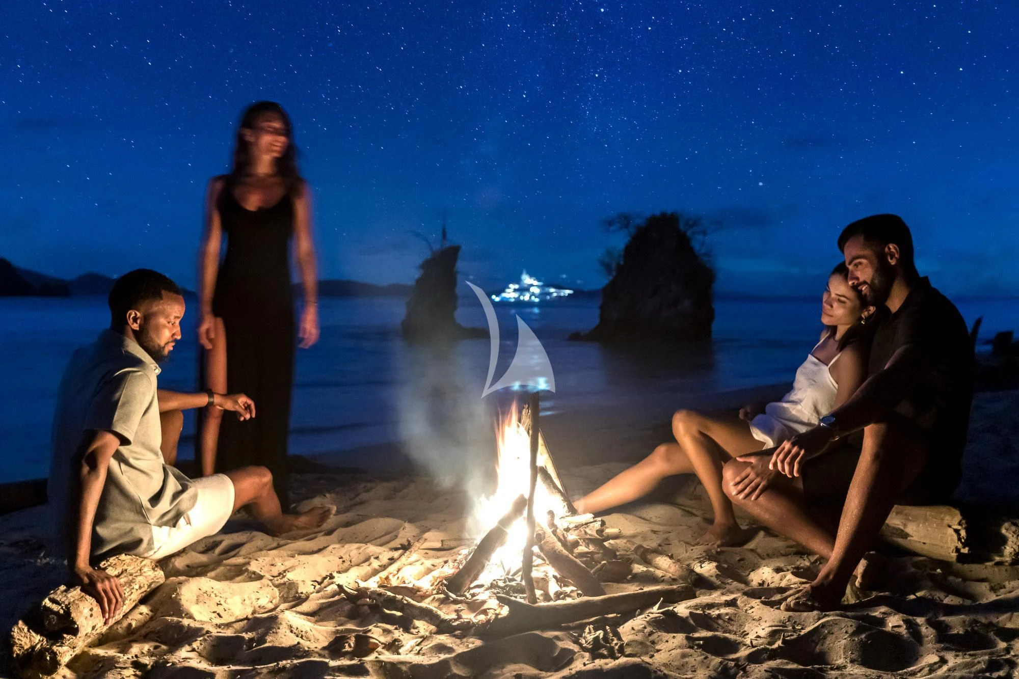 a group of people sitting on a beach with a man and a woman aboard FORMOSA Yacht for Sale