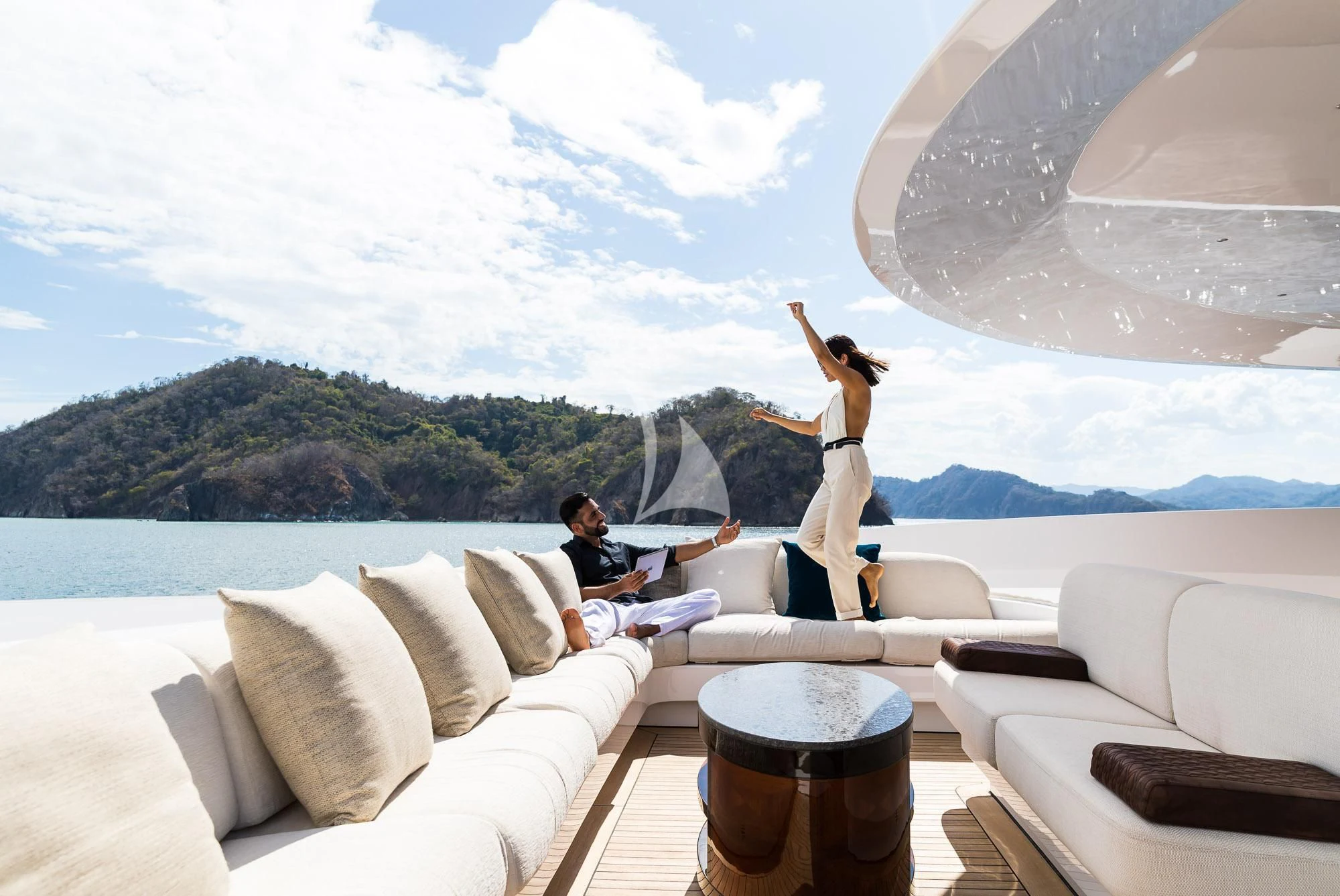 a woman sitting on a couch with a man sitting on a couch aboard FORMOSA Yacht for Sale