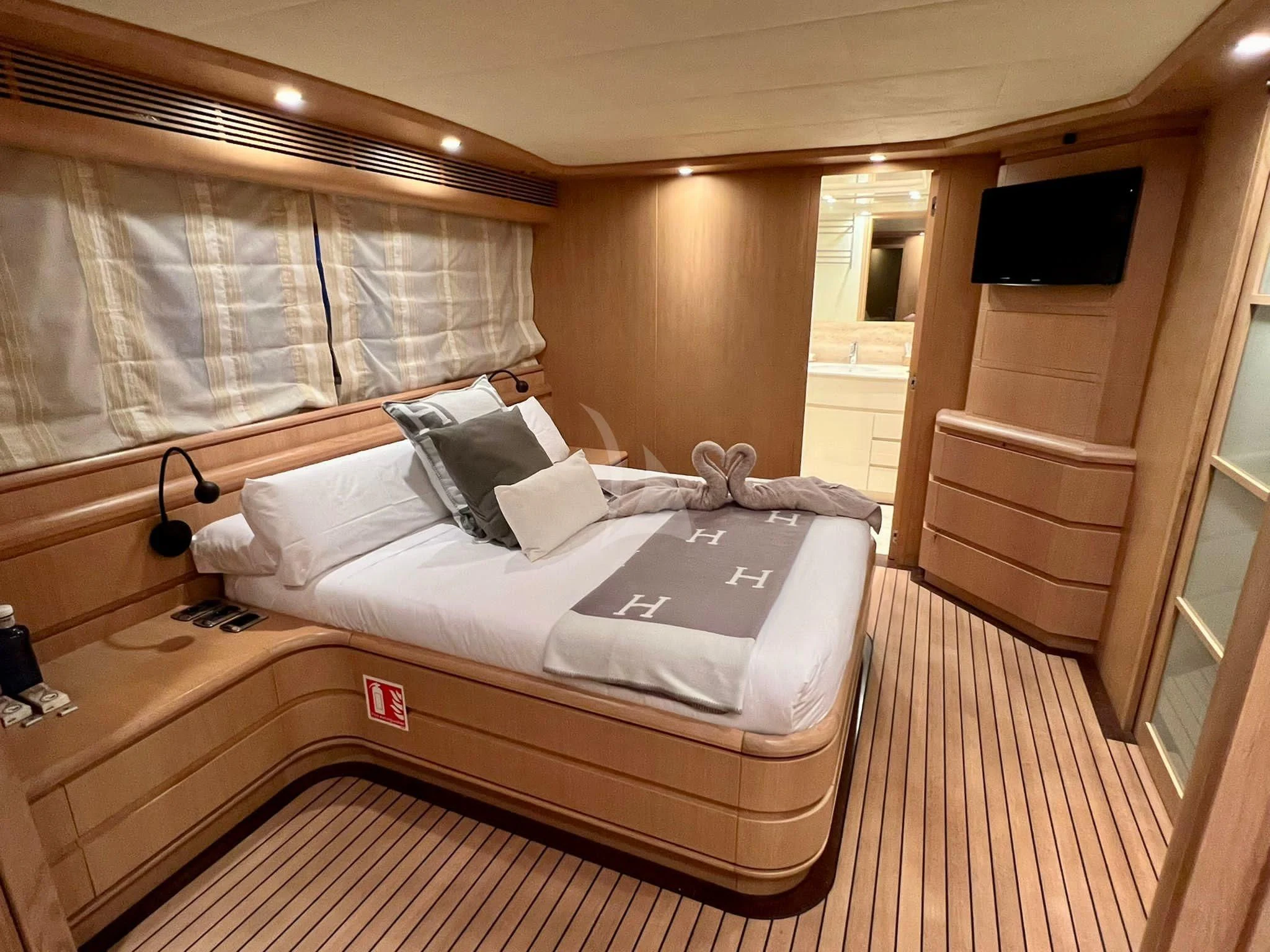 a room with a bed and a television aboard B4 Yacht for Charter