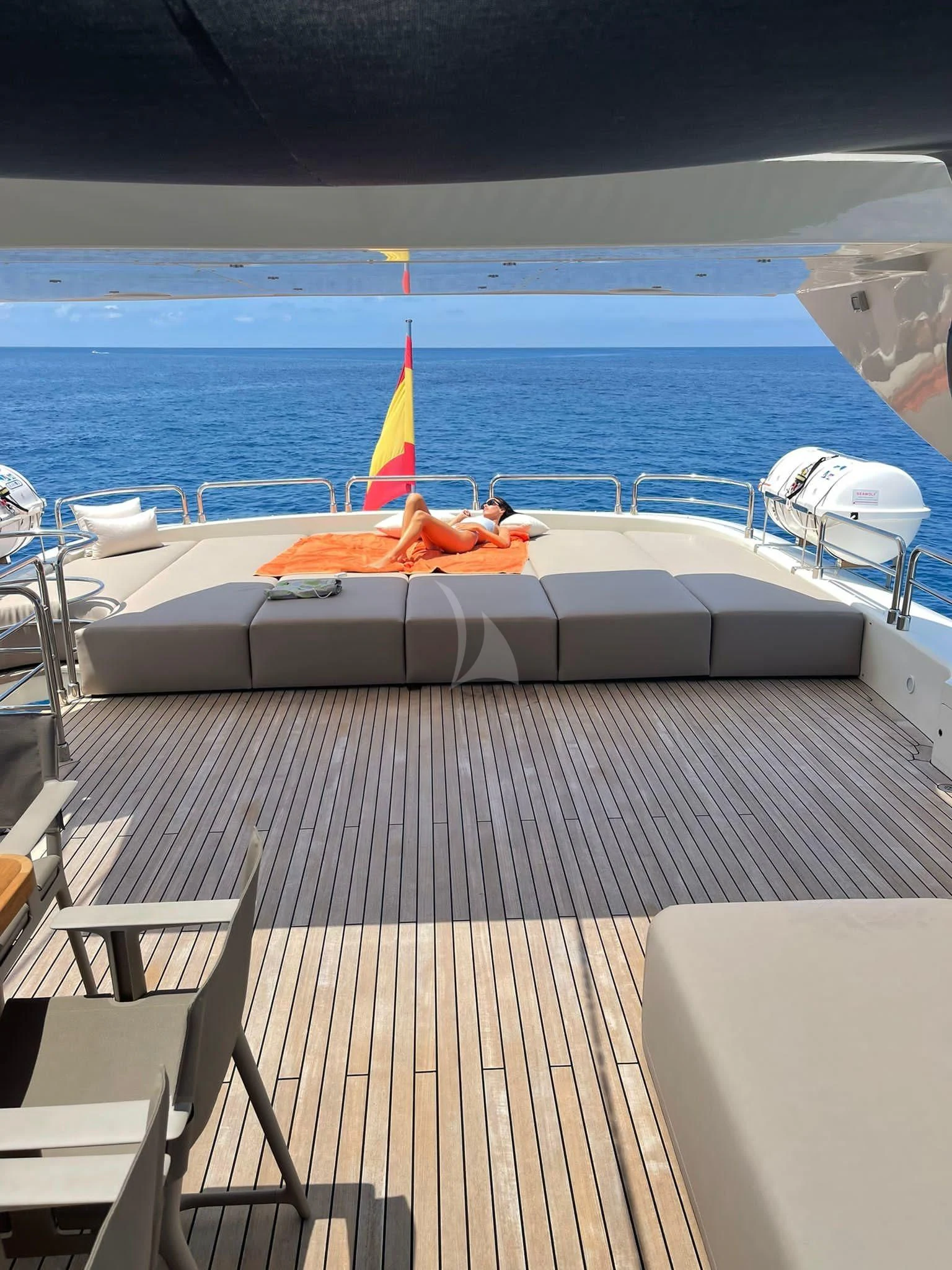 a deck with a large body of water and a boat on it aboard B4 Yacht for Charter