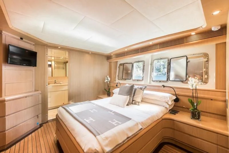 a room with a bed and a television aboard B4 Yacht for Charter