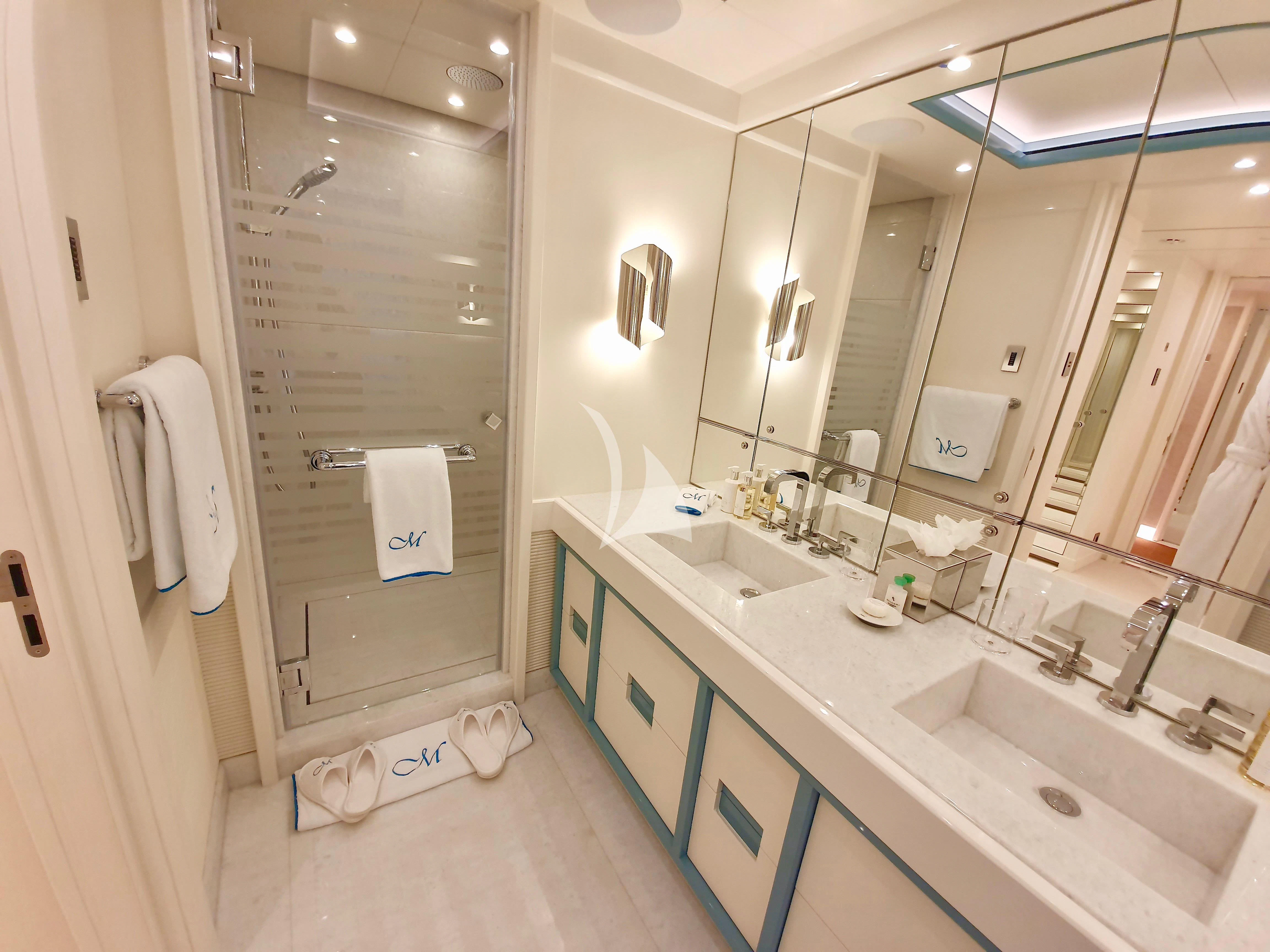 a bathroom with a shower and sinks aboard MIMTEE Yacht for Sale
