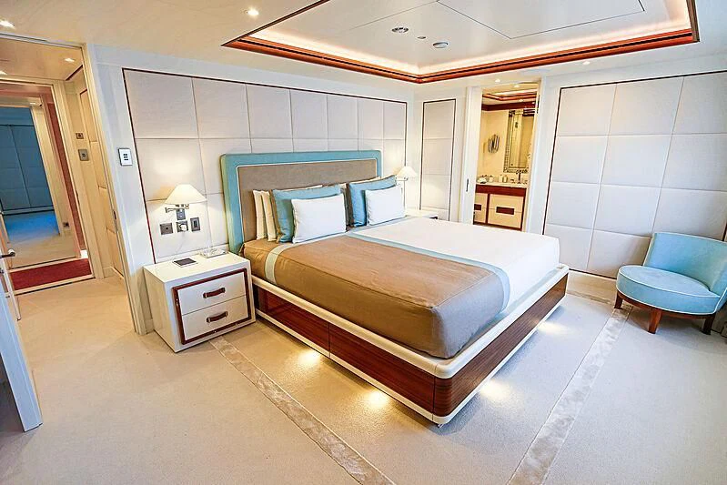 a bedroom with a bed and a chair aboard MIMTEE Yacht for Sale