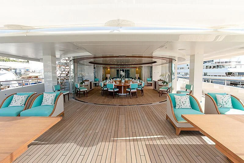 a room with a wood floor and a table with chairs and a large window with a view of aboard MIMTEE Yacht for Sale