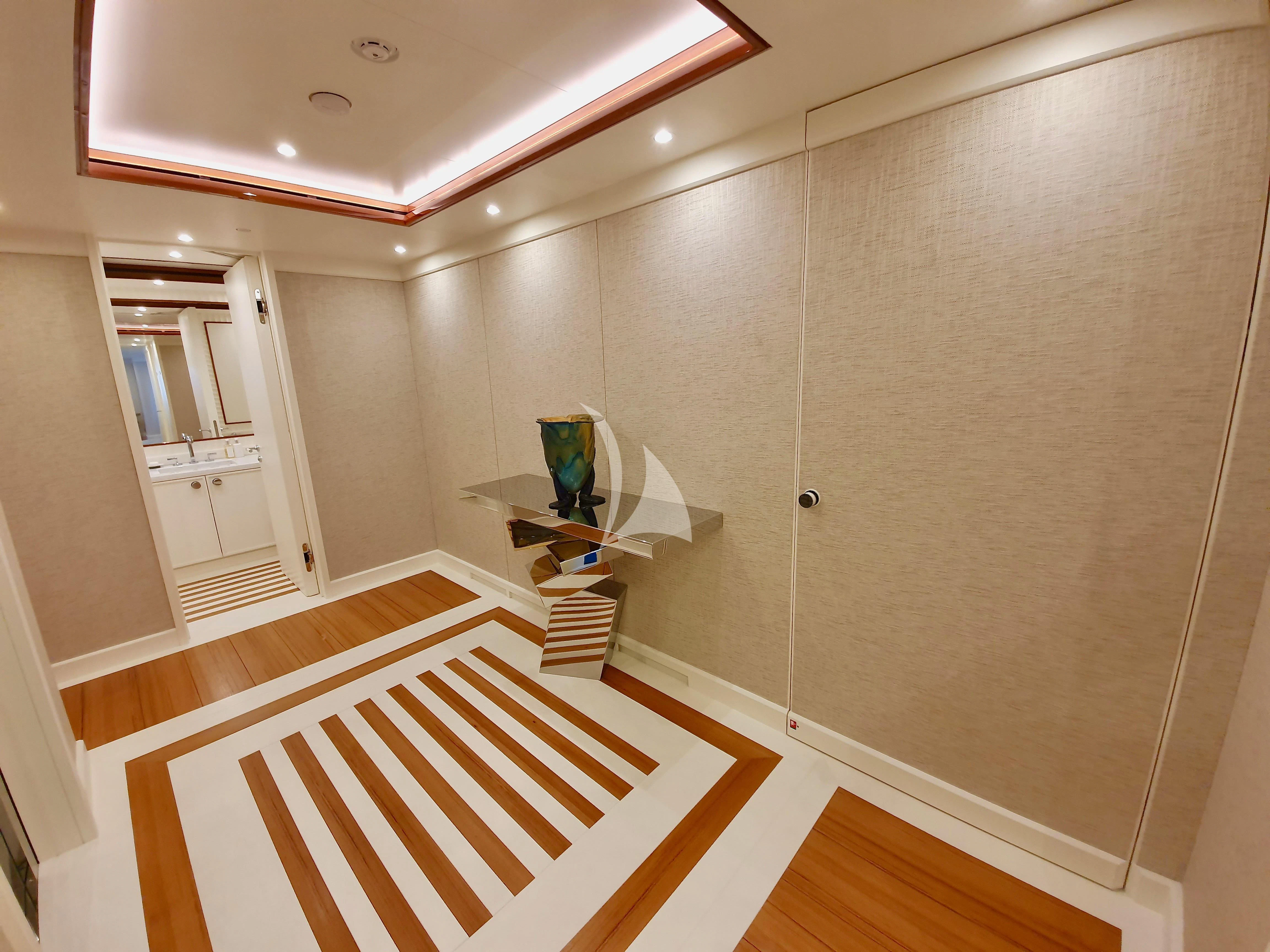 a room with a table and a vase on a stand aboard MIMTEE Yacht for Sale