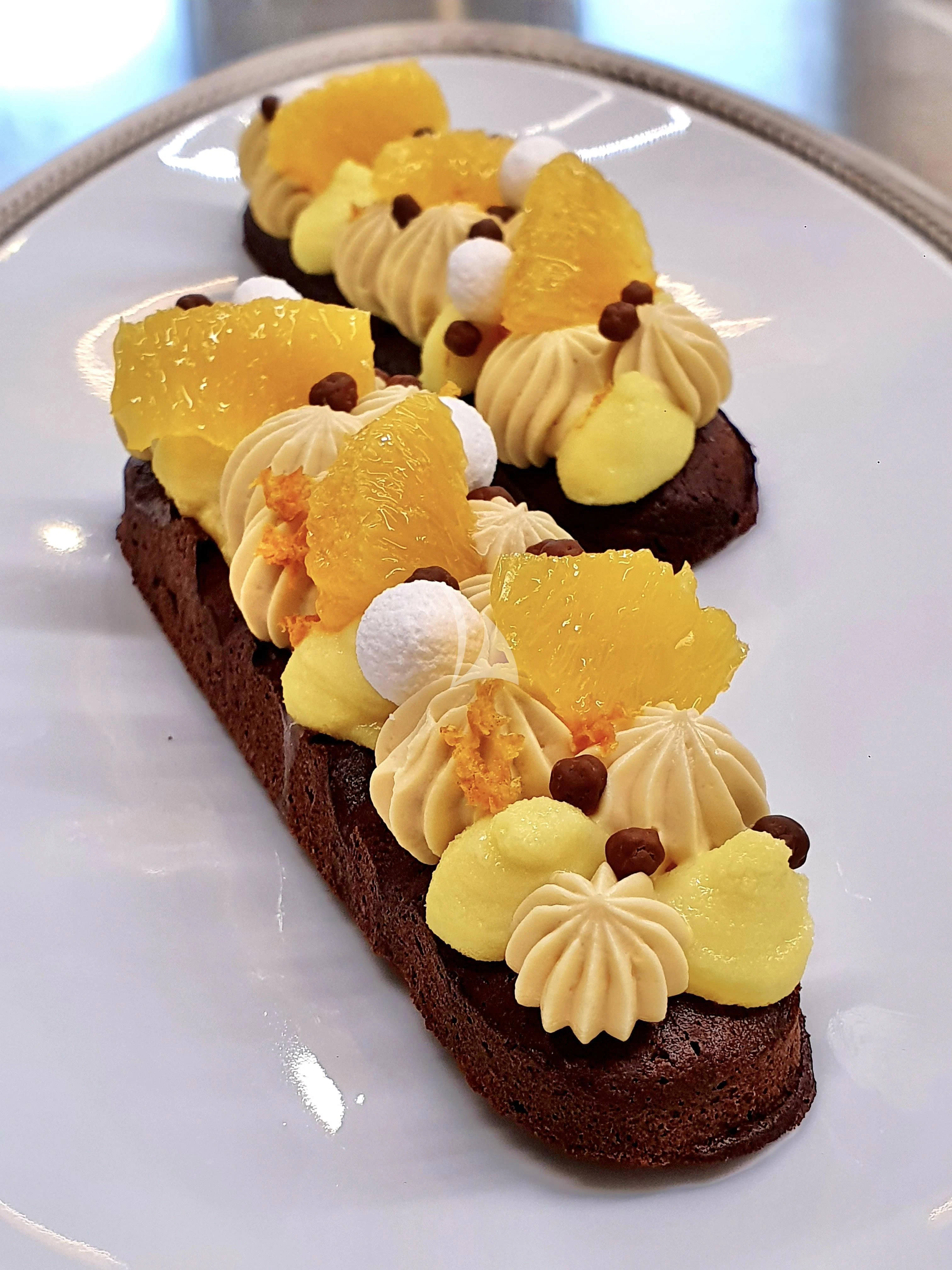 a plate of cupcakes with yellow cream and chocolate toppings aboard MIMTEE Yacht for Sale