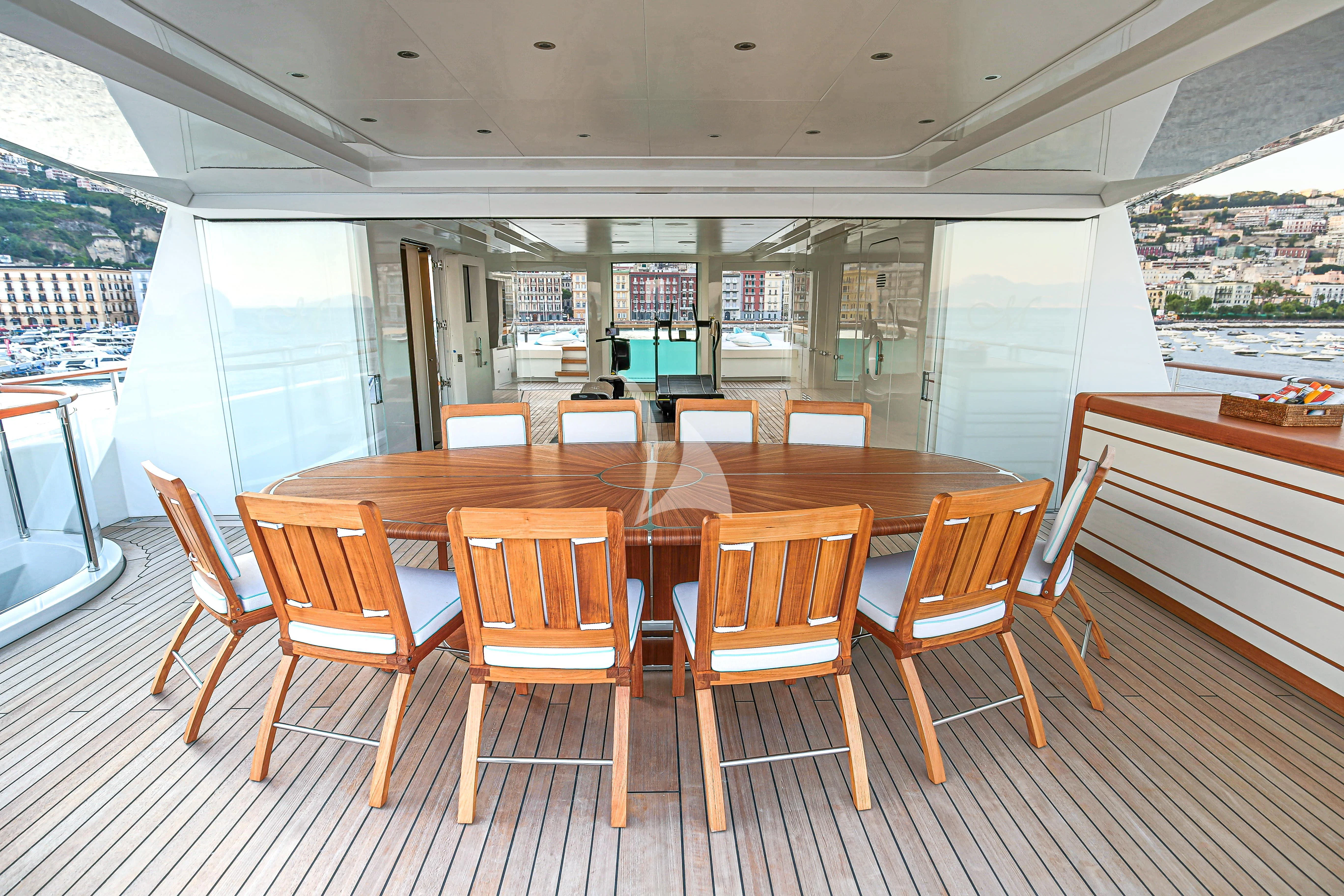 a large wooden table with chairs around it aboard MIMTEE Yacht for Sale
