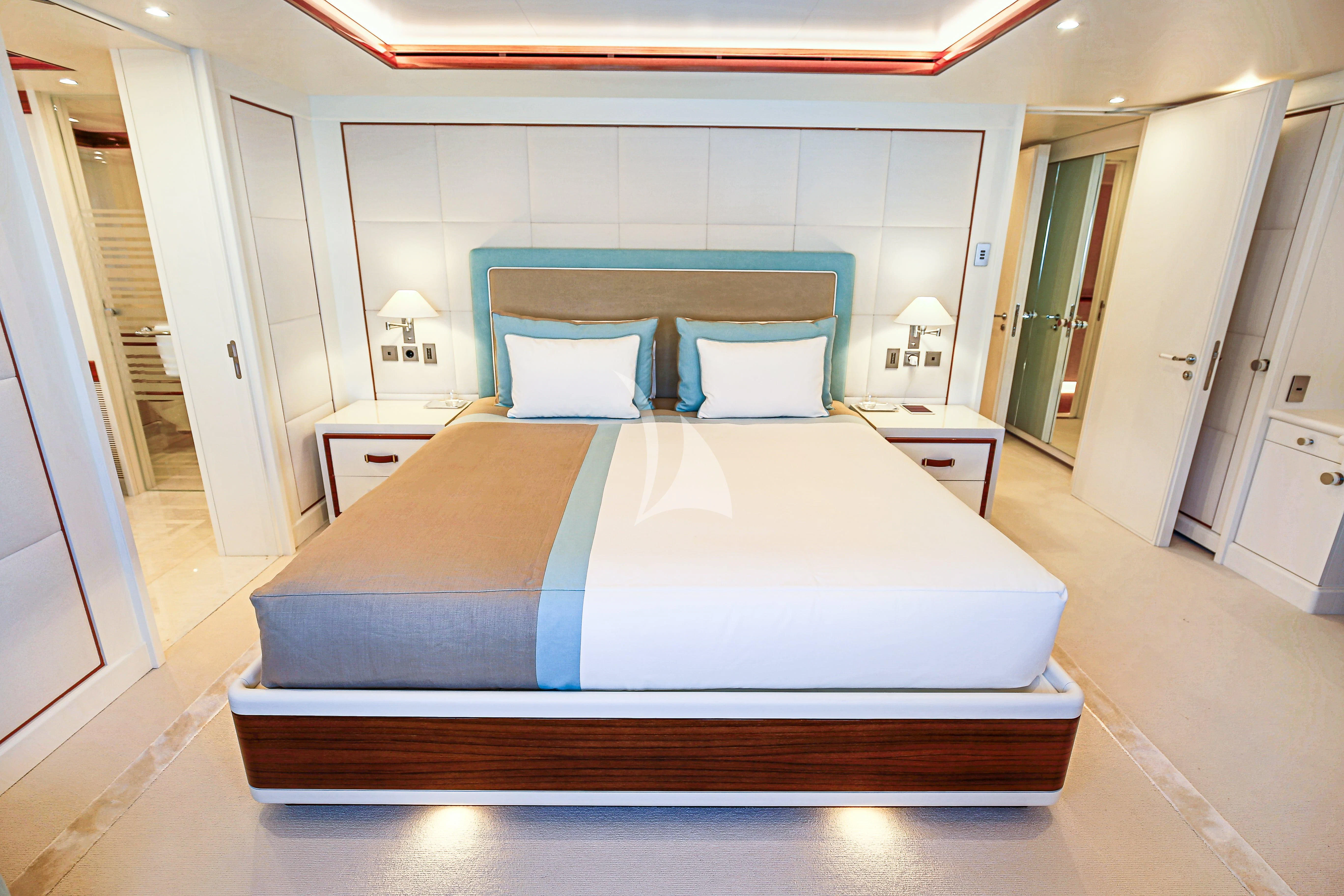 a bed with a blue and white comforter aboard MIMTEE Yacht for Sale